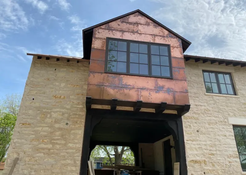 Copper metal panel facade on a stone building for Roof Repair in Stewartville